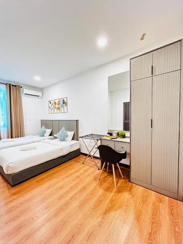 a bedroom with a bed and a desk and a table at LESTARI INN RESIDENCE in Kuantan