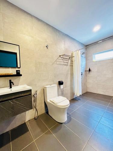 a bathroom with a toilet and a sink and a shower at LESTARI INN RESIDENCE in Kuantan