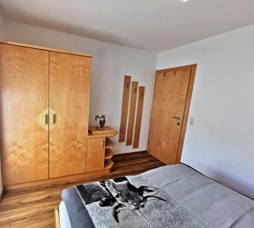 a bedroom with a bed and wooden cabinets at Gschlössl, Ferienhaus in Rauris