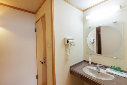 a bathroom with a sink and a mirror at Ashibetsu Onsen Starlight Hotel in Ashibetsu