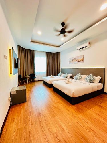 a bedroom with two beds and a ceiling fan at LESTARI INN RESIDENCE in Kuantan