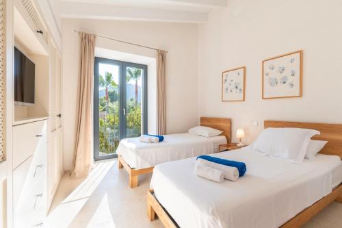 two beds in a room with a window at Ca Na Maronja in Pollença