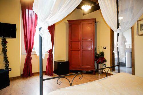 una camera da letto con letto e tende rosse e bianche di Sul Prado a Pietrasanta