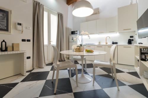 a white kitchen with a white table and chairs at TEATRUM LOFT Teatro Galli -Jacuzzi in camera in Rimini