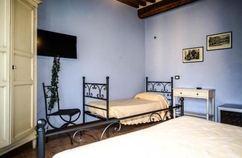 a bedroom with a bed and a chair and a tv at Sul Prado in Pietrasanta