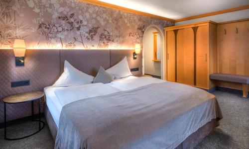 a bedroom with a large white bed in a room at Hotel Königgut in Wals