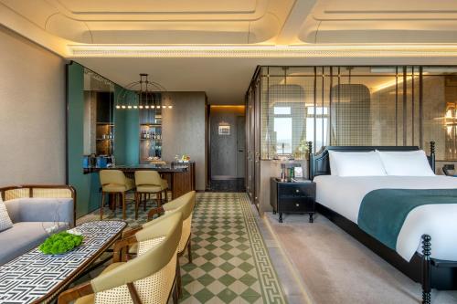 a hotel room with a bed and a bar at Xiamen Lujiang Harbourview Hotel in Xiamen