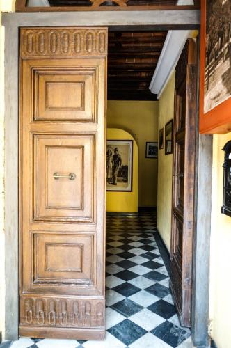 a wooden door in a hallway with a checkered floor at Sul Prado in Pietrasanta