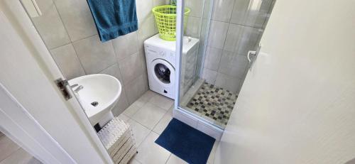 y baño con ducha y lavadora. en Calamari 9 - 6 Sleeper - 30 Steps From The Beach!, en Margate