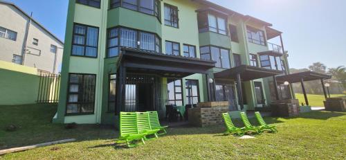 un grupo de sillas verdes frente a un edificio en Calamari 9 - 6 Sleeper - 30 Steps From The Beach!, en Margate