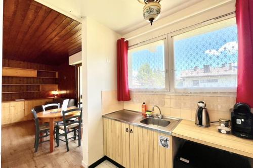 une cuisine avec un évier, une table et une fenêtre dans l'établissement Charming cocoon in Megève center, à Megève