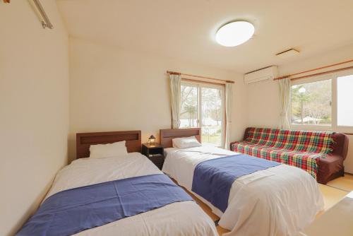 a room with two beds and a couch at Lakeside Hotels Kuore in Kitashiobara