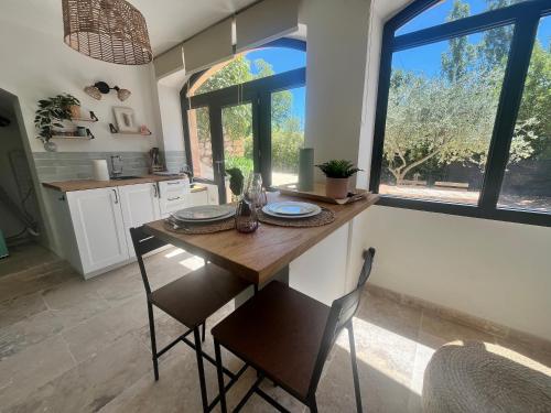 エクス・アン・プロヴァンスにあるAix-en-Provence, Cosy studio au calme de la campagne avec Spa et Climのキッチン(木製テーブル、椅子、窓付)