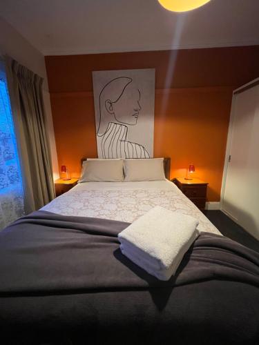 a bedroom with a bed with a painting on the wall at Room @ 88 in Devonport