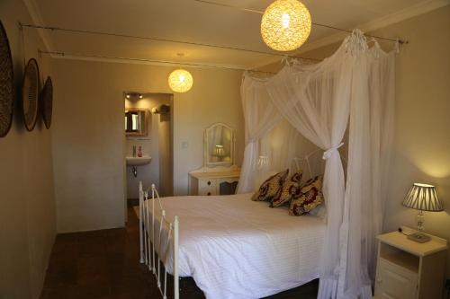 a bedroom with a white bed with a canopy at Wildebeest Eco Camp in Nairobi