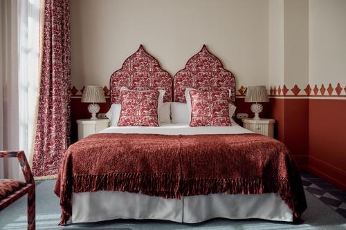 a bedroom with a large bed with red pillows at Cristine Bedfor Sevilla in Seville