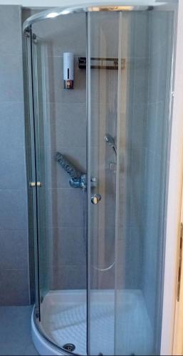 a shower with a glass door in a bathroom at "Akrivis studio" in Athens