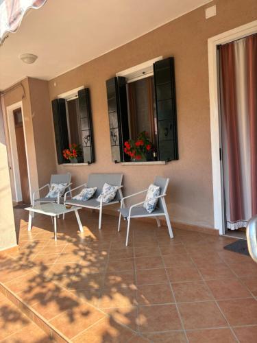a patio with chairs and a table and windows at A Casa dei Nonni in Cavallino-Treporti