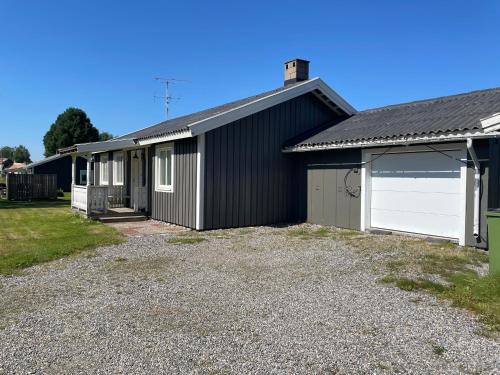 a black house with a white garage at Centralt belägen villa i Öjebyn, Piteå in Piteå