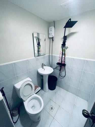 a bathroom with a toilet and a sink at J&J Mactan Stays with Netflix, Pool & Paid Parking in Suba
