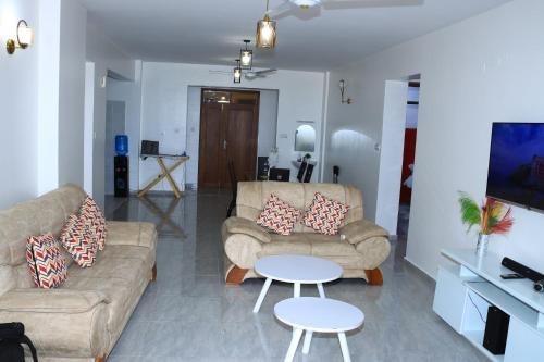 a living room with two couches and a table at Luxurious apartments Mombasa in Mombasa