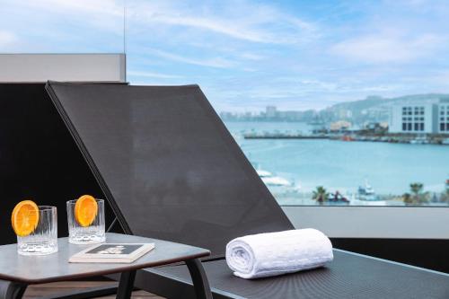 a table with two glasses and a towel and a window at Hotel Puerto de la Luz by Pierre & Vacances in Las Palmas de Gran Canaria