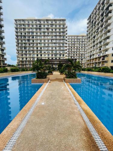 a large apartment building with a large swimming pool at J&J Mactan Stays with Netflix, Pool & Paid Parking in Suba