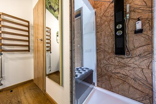 a bathroom with a shower with a mirror at AKIS namelis medyje- Dinosaur Park in Radailiai