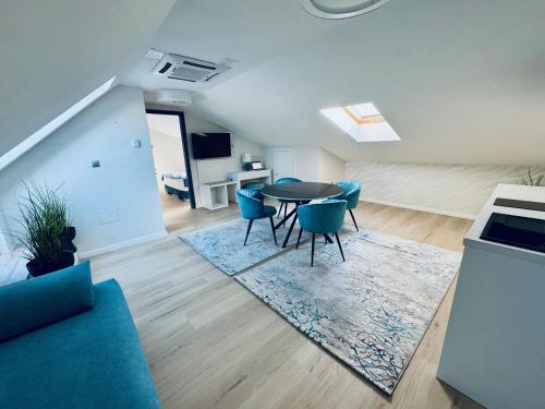 a living room with a table and blue chairs at Duna Corner Panzió in Verőce