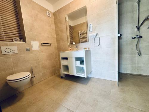 a bathroom with a toilet and a shower and a sink at Duna Corner Panzió in Verőce