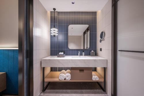 a bathroom with a sink and a mirror at Novotel Hangzhou Yuhang in Yuhang