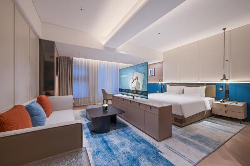 a hotel room with a bed and a couch at Novotel Hangzhou Yuhang in Yuhang