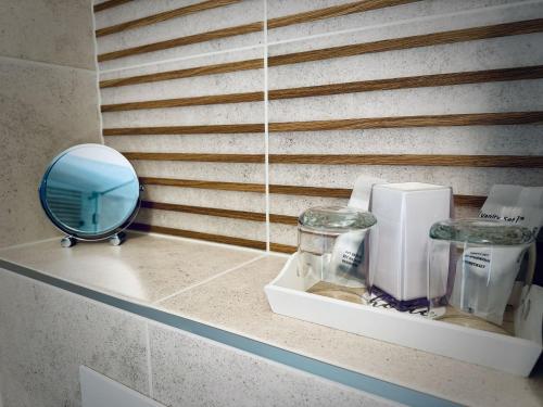 a mirror and other items on a shelf in a bathroom at Duna Corner Panzió in Verőce