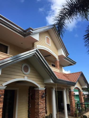 a yellow house with a brown roof at Tagaytay Rest House in Tagaytay