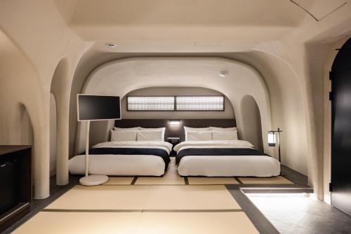 a bedroom with two beds and a tv at Cave Ryokan Hotel by Aank Sungshin Women's University in Seoul