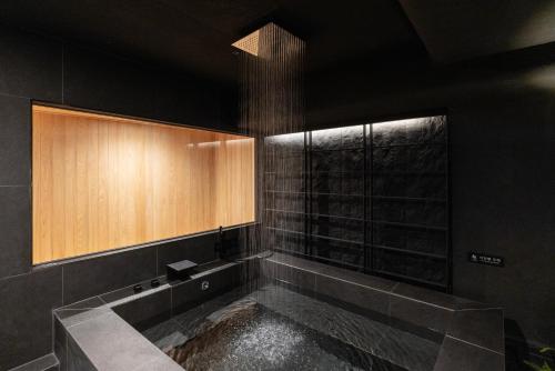 a bathroom with a bath tub with a window at Cave Ryokan Hotel by Aank Sungshin Women's University in Seoul