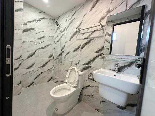 a bathroom with a toilet and a sink at 25House Cozy Apartment near West Lake & Airport in Hanoi