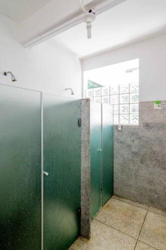 a bathroom with a green door in a room at Casa Bacarirá - Floresta com Yoga e Café da Manhã Vegano in Camburi