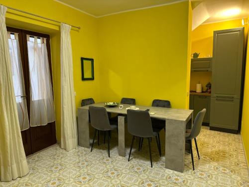 a dining room with yellow walls and a table and chairs at Garçonnière Casa Caterina in Ischia
