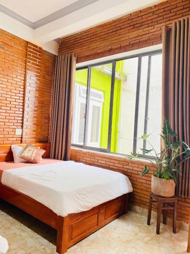 a bedroom with a bed and a large window at Dalat Note Hostel in Da Lat