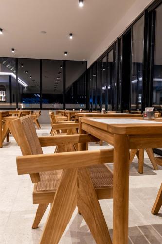 a row of wooden tables in a restaurant at Marbella Sol Hotel - Only Adults in Ksamil