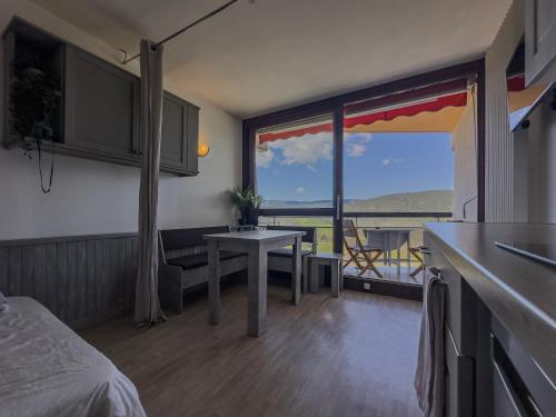 a room with a bed and a table with a view at Le Chamois - Au pied des Pistes in Villard-de-Lans