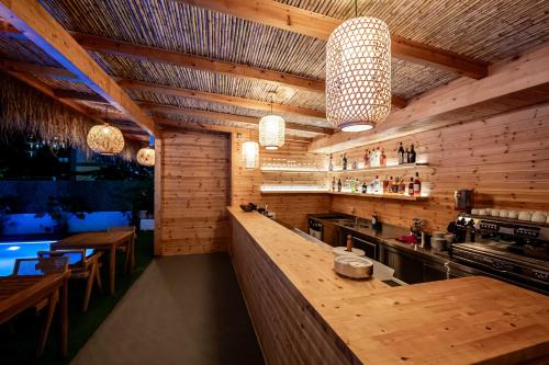 a kitchen with wooden walls and a bar with lights at Marbella Sol Hotel - Only Adults in Ksamil