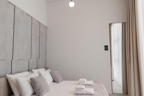 a bedroom with a bed with white pillows and a mirror at Marbella Sol Hotel - Only Adults in Ksamil