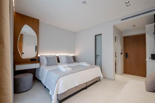 a bedroom with a large bed and a mirror at Marbella Sol Hotel - Only Adults in Ksamil