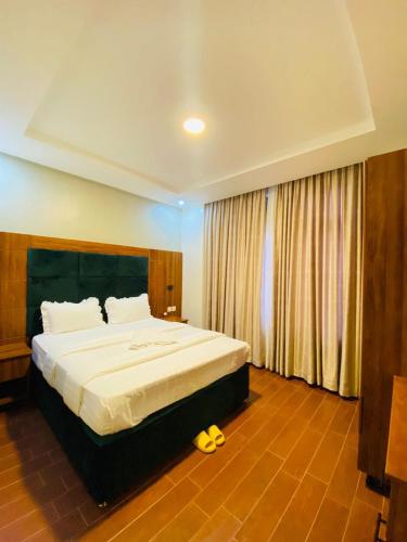 a bedroom with a large bed with a yellow stuffed animal at Jikoni Hotel in Gisenyi