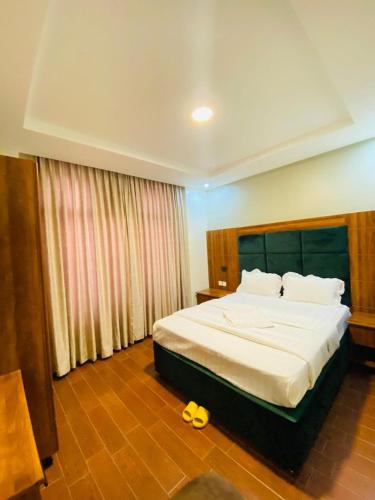 a bedroom with a large bed with a yellow toy at Jikoni Hotel in Gisenyi