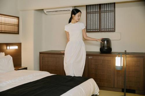 a woman standing on a counter in a hotel room at Cave Ryokan Hotel by Aank Sungshin Women's University in Seoul