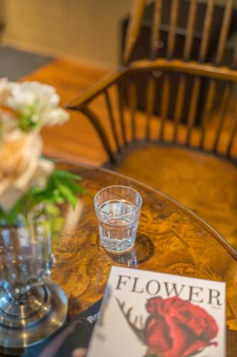 a wooden table with a glass bowl of water and a sign at 箱根シャレー コンビニ近く 海賊船に乗ろう 箱根中心 in Hakone