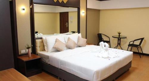a bedroom with a large white bed with a mirror at Rest@Ratchada hotel in Bangkok